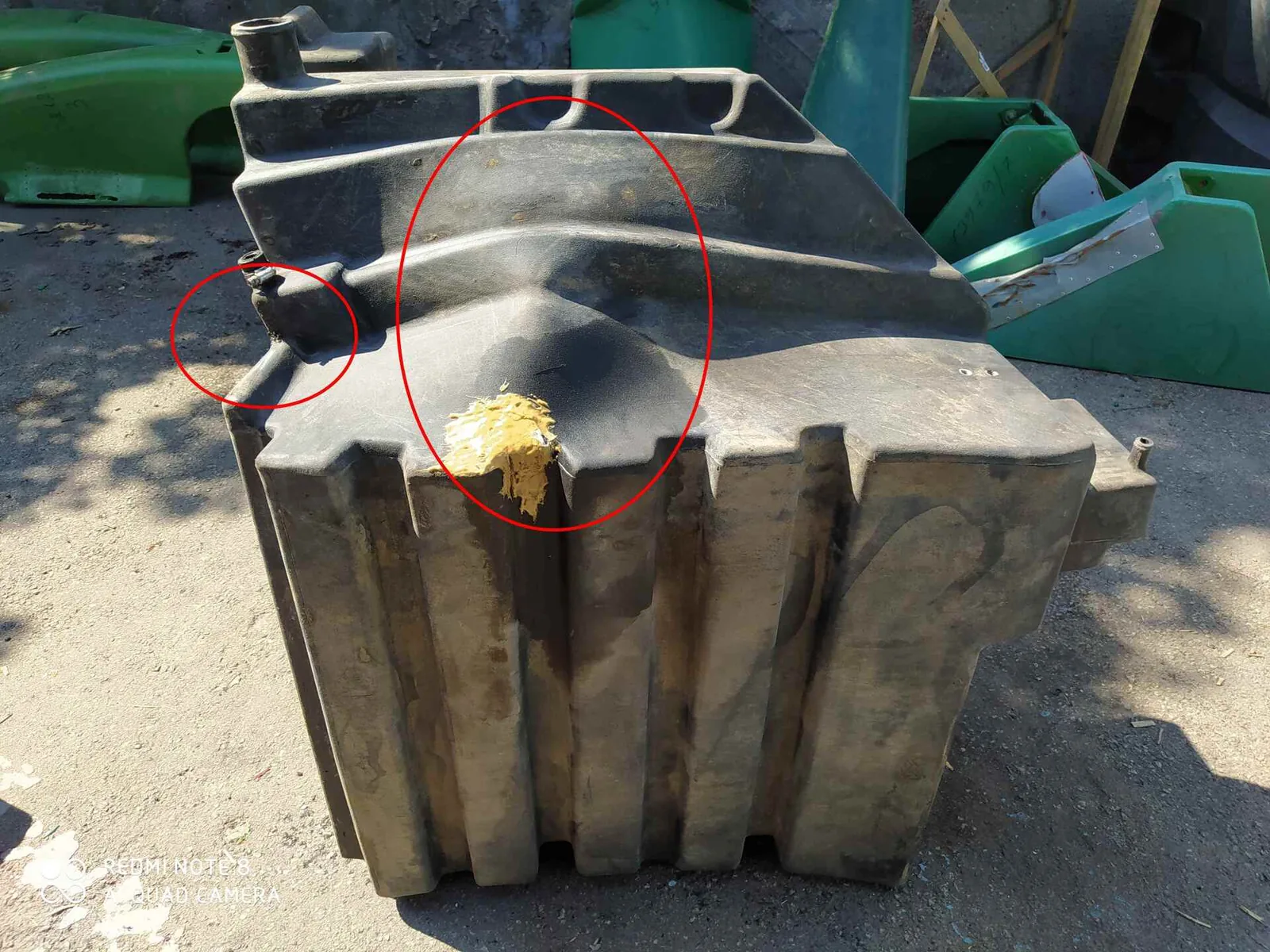Gerissener Kunststoff-Kraftstofftank eines Traktors Case 340 vor der Reparatur